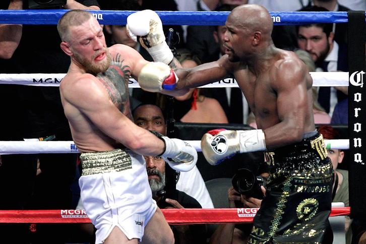 McGregor y Mayweather, en el cuadrilátero durante la pelea. (John GURZINSKI/AFP)