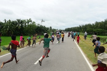 Menores rohingyas refugiados en Bangladesh corren tras un vehículo que reparte ayuda. (Munir UZ ZAMAN/AFP)