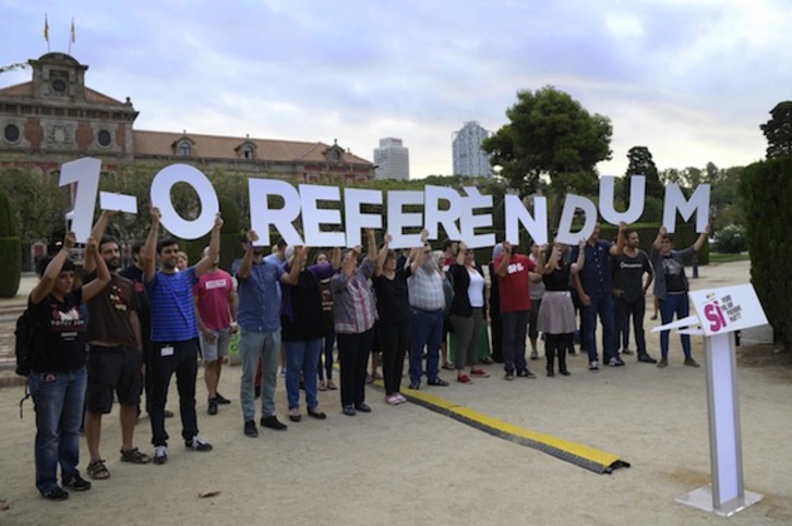 Miembros de la CUP, en un acto anterior en defensa del 1-O. (Lluis GENÉ/AFP)