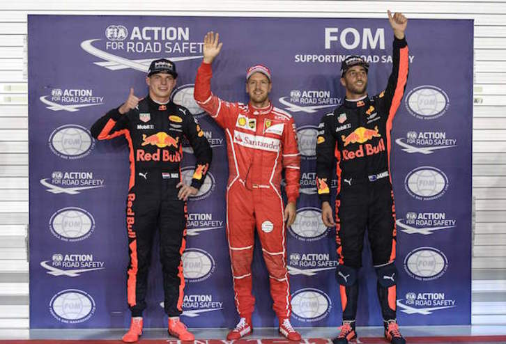 Vettel, flanqueado por los dos pilotos de Red Bull. (Mohd RASFAN / AFP)