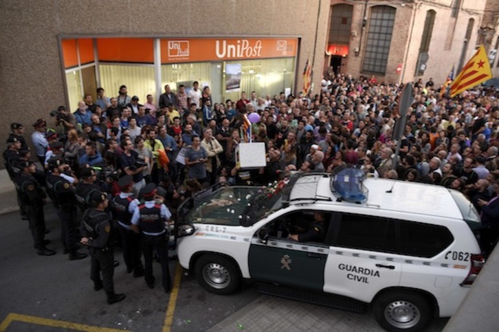 Vecinos de Terrassa concentrados frente a la sede de la empresa Unipost, durante un registro en vísperas del 1-O.  (Josep LAGO/AFP)