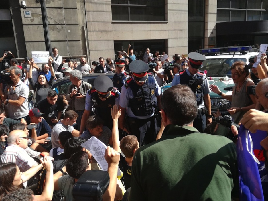 Sentada ante un vehículo de la Guardia Civil en Exteriores, cuando se iban a llevar a un detenido. (@Ion_Salgado)