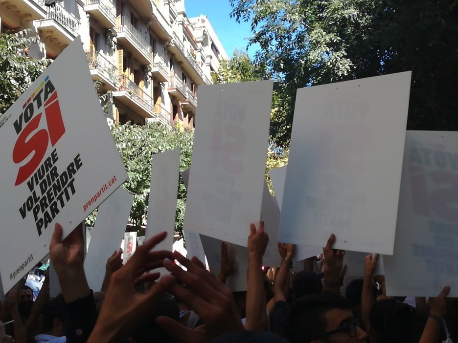 Carteles que han repartido en el exterior de la sede de la CUP. (@Ion_Salgado)