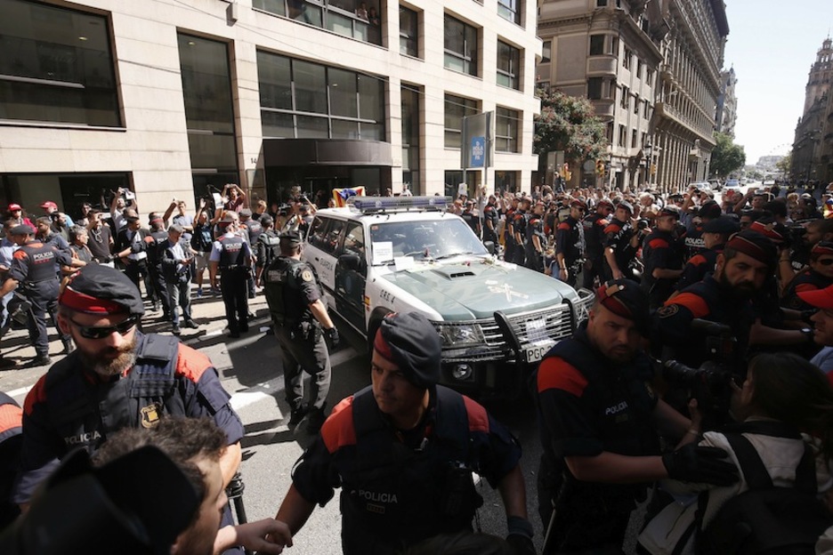 Los Mossos protegen un patrol de la Guardia Civil. (Pau BARRENA/AFP)