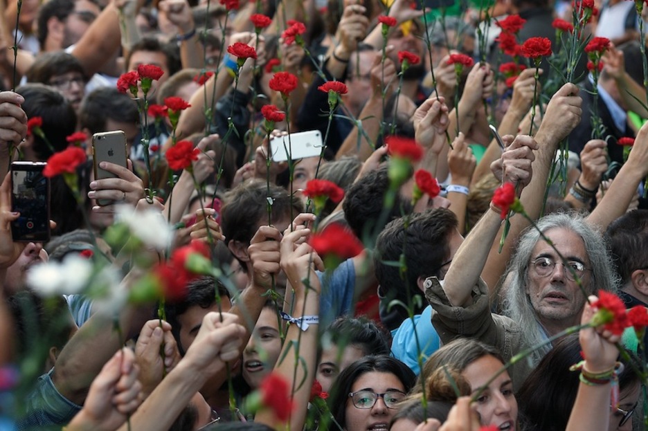 Claveles frente a los arrestos y registros. (Lluis GENE/AFP)