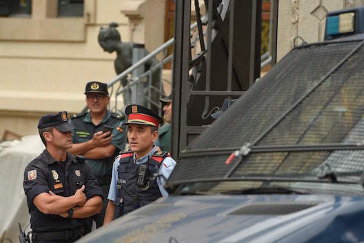 Agentes de los Mossos, Policía española y Guardia Civil, en el exterior mientras los mandos celebraban la reunión. (Lluis GENE / AFP)