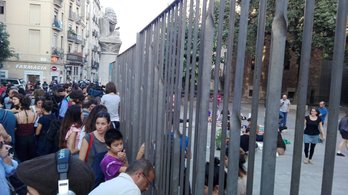 Un colegio del Raval, donde la puerta, por ahora, permanece cerrada pero hay gente tanto fuera como dentro del centro