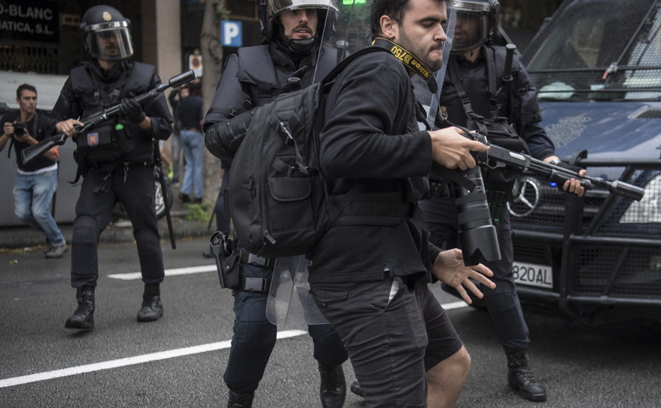 Policías empujan a un fotógrafo en el Eixample barcelonés. (Jagoba MANTEROLA/ARGAZKI PRESS)