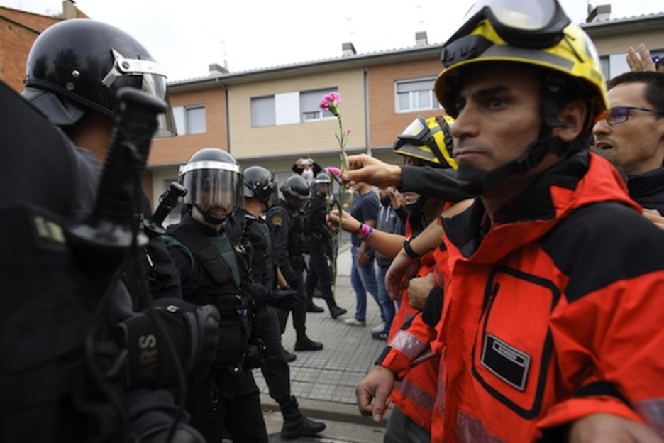 Bomberos frente a guardias civiles en Sant Julià de Ramis. (Lluís GENÉ/AFP)