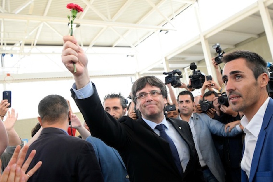 Carles Puigdemont, clavel en mano, ha visitado el colegio donde tenía que haber votado. (Lluís GENÉ/AFP)