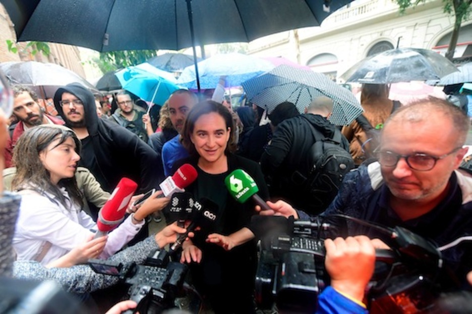 La alcaldesa de Barcelona, Ada Colau, rodeada de periodistas cuando ha acudido a votar. (José JORDÁN/AFP)