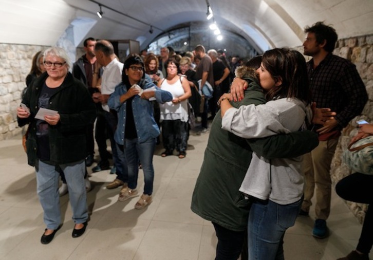 Dos mujeres se abrazan tras votar en Lladó. (César MANSO/AFP)