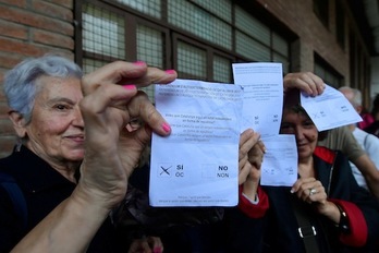 Varias mujeres muestran sus votos a la entrada de su colegio electoral. (José JORDÁN/AFP)