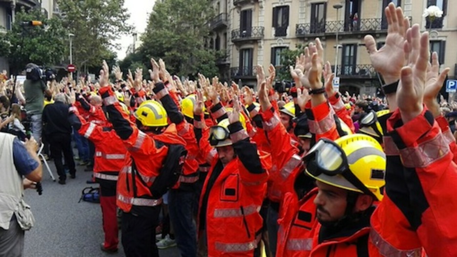 Los bomberos se han concentrado en silencio y con los brazos en alto frente a la Delegación del Gobierno español. (@iontelleria)