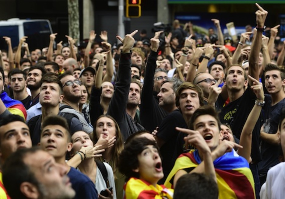 Un grupo de personas «saluda» al helicóptero policial que sobrevuela Barcelona. (Pierre-Philippe MARCOU/AFP)
