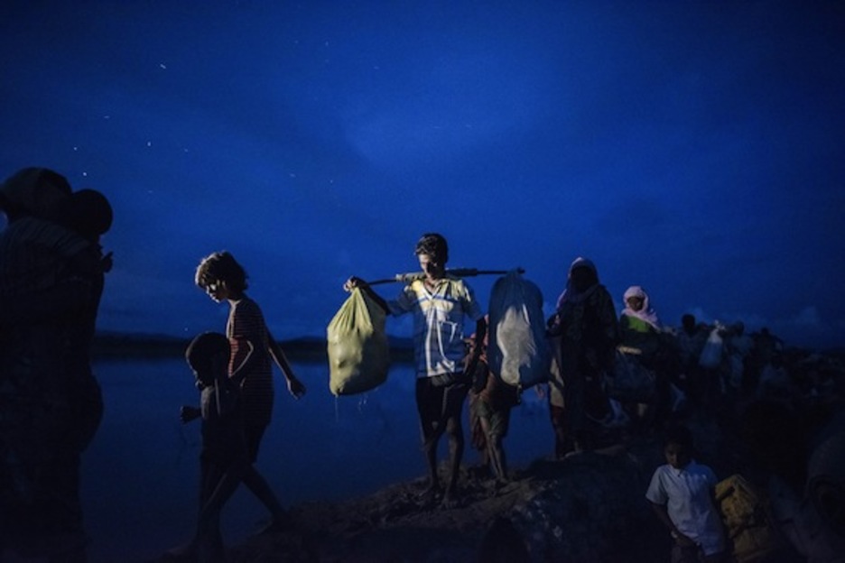 Refugiados aguardan tras cruzar el río Naf. (Fred DUFOUR/AFP)