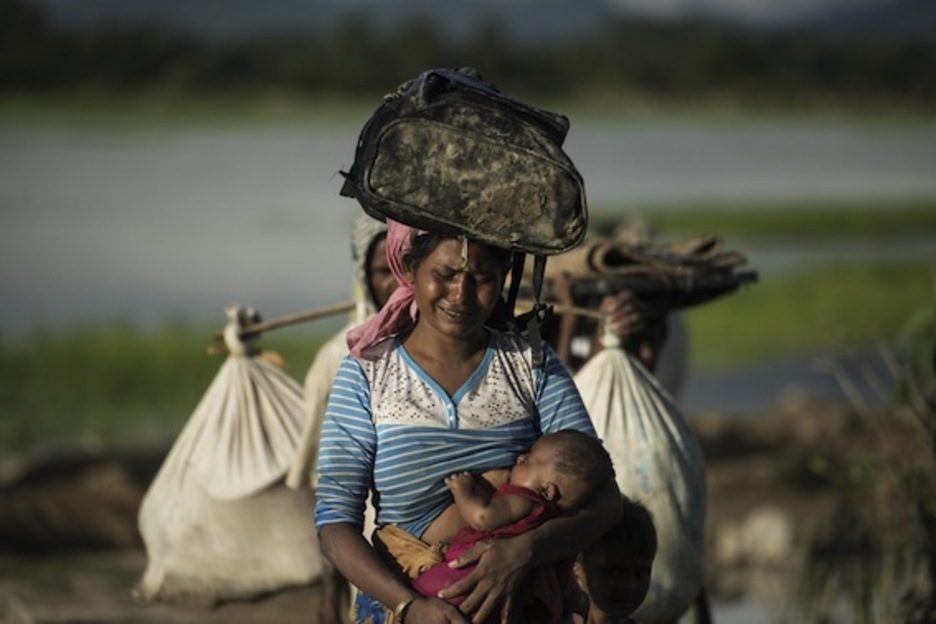 Una mujer cruza llorando el río Naf. (Fred DUFOUR/AFP)