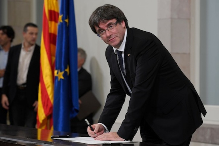 Carles Puigdemont, firmando la declaración de independencia. (Lluís GENÉ/AFP)