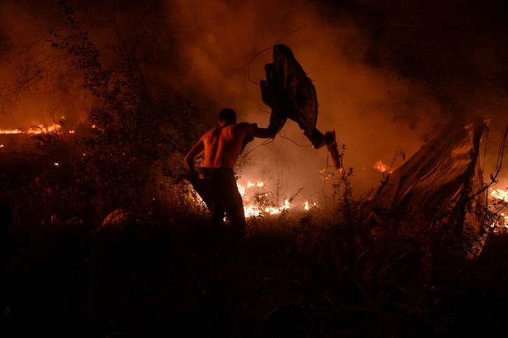 Un hombre intenta apagar las llamas en Vigo. (Miguel RIOPA/AFP) 