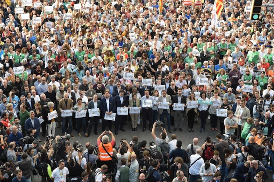 La prensa fotografía a los cargos institucionales. (Lluís GENE/AFP)