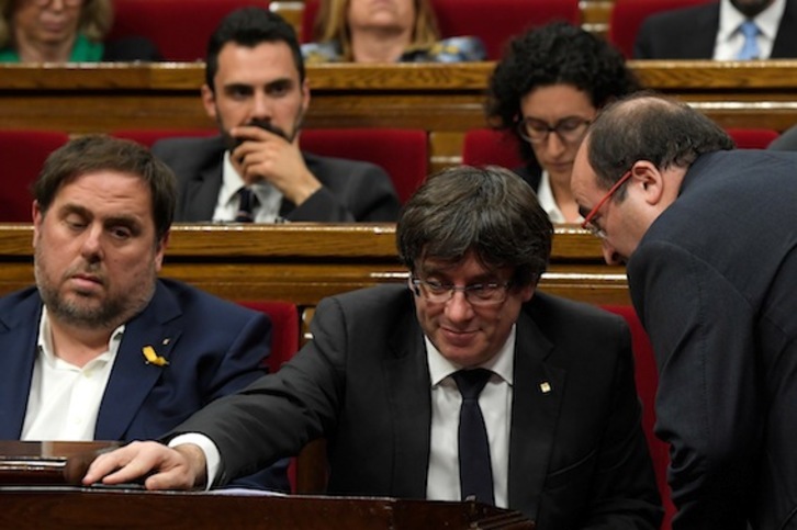 El secretario general del PSC, Miquel Iceta, habla con Carles Puigdemont en el pleno de ayer. (Lluis GENÉ/AFP)