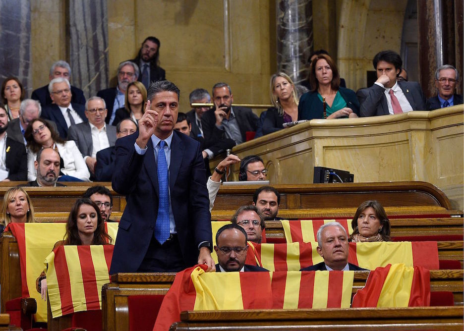 El PP ha sacado senyeras y banderas españolas antes de abandonar el hemiciclo. (Lluis GENE / AFP)