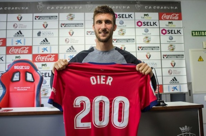 Oier muestra la camiseta con la que ha sido homenajeado por cumplir 200 partidos con el primer equipo. (OSASUNA)