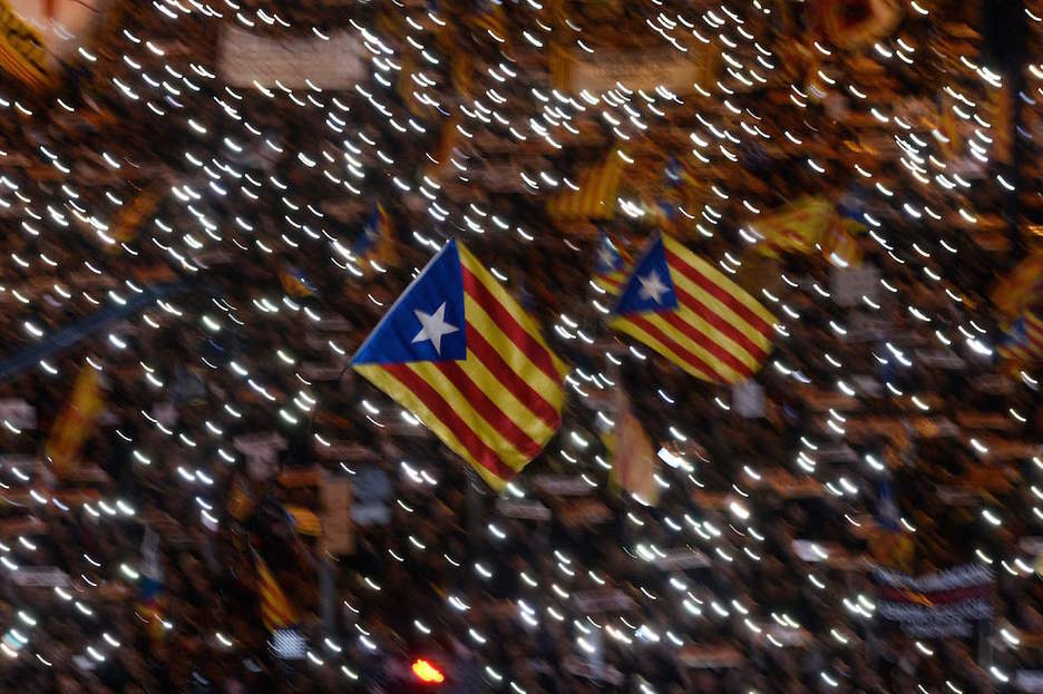 Bi estelada bertaratuen mugikorretako argien artean. (Josep LAGO | AFP) Bi estelada bertaratuen mugikorretako argien artean. (Josep LAGO | AFP)
