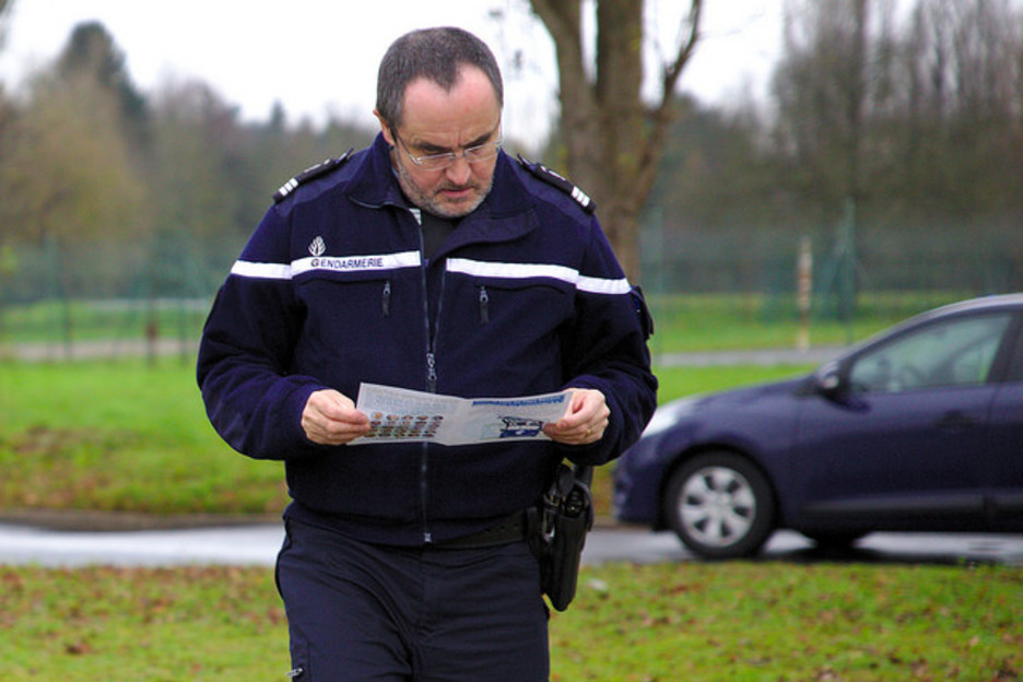 Jendarme bat martxako kideek banatu dituzten eskuorria irakurtzen. Jendarme bat martxako kideek banatu dituzten eskuorria irakurtzen.