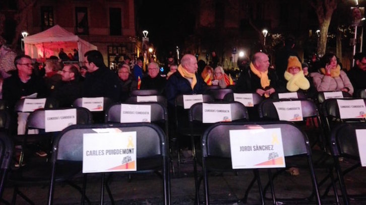 Sillas con los nombres de quienes no pueden asistir al último mitin de Junts per Cat. (@iontelleria)