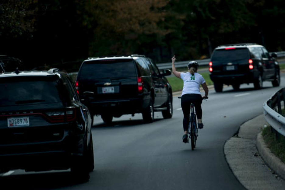 Una imagen que se hizo viral: esta ciclista daba su gráfica opinión al paso de la comitiva presidencial estadounidense en octubre en Sterling (Virginia). (Brendan SMIALOWSKI)