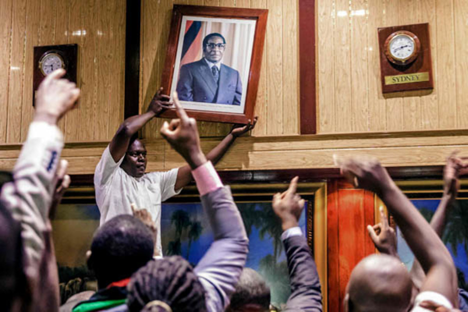 Diputados del Parlamento de Zimbabue retiran el retrato de Robert Mugabe que, a sus 93 años y tras 37 en el poder, tuvo que renunciar a su cargo por la presión militar y ciudadana. (Jekesai NHIKIZANA)