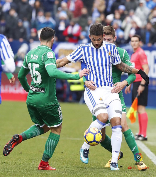 William José protege el balón frente a dos adversarios. (@RealSociedad)