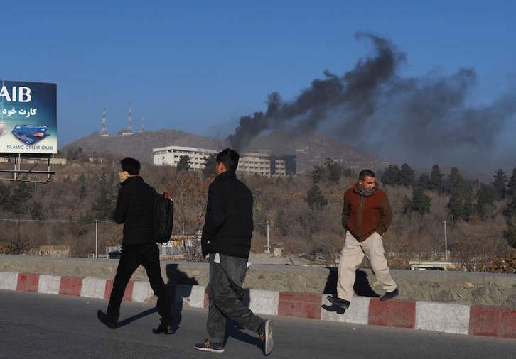 El hotel, al fondo de la imagen, todavía en llamas. (Wakil KOHSAR/AFP)