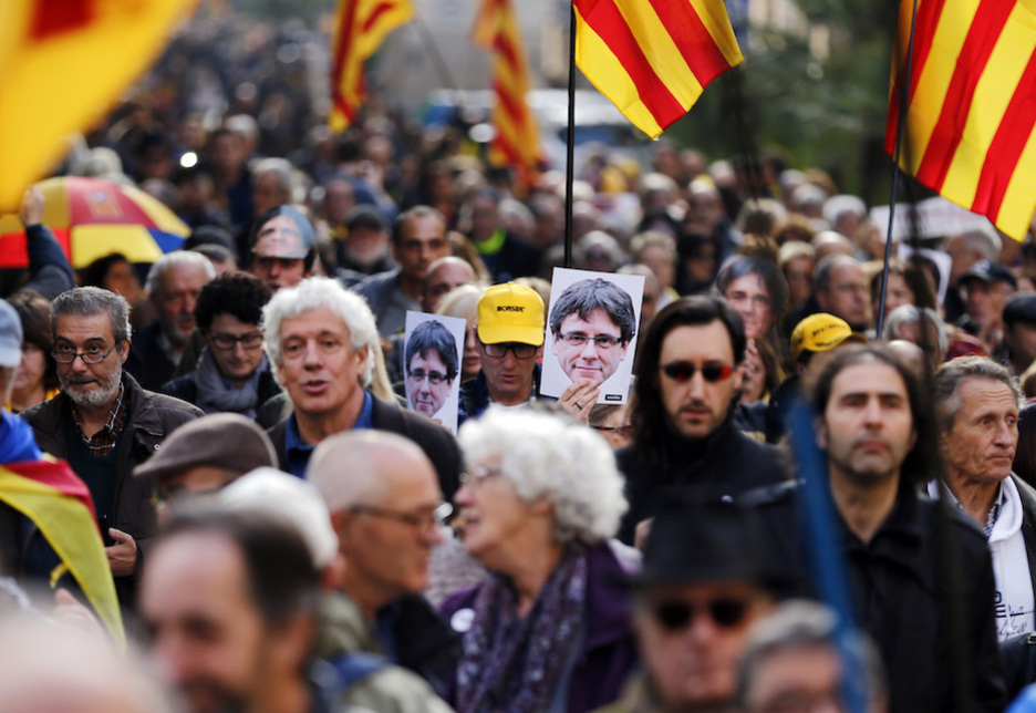 Manifestantes con carteles de Puigdemont. (Pau BARRENA / AFP)