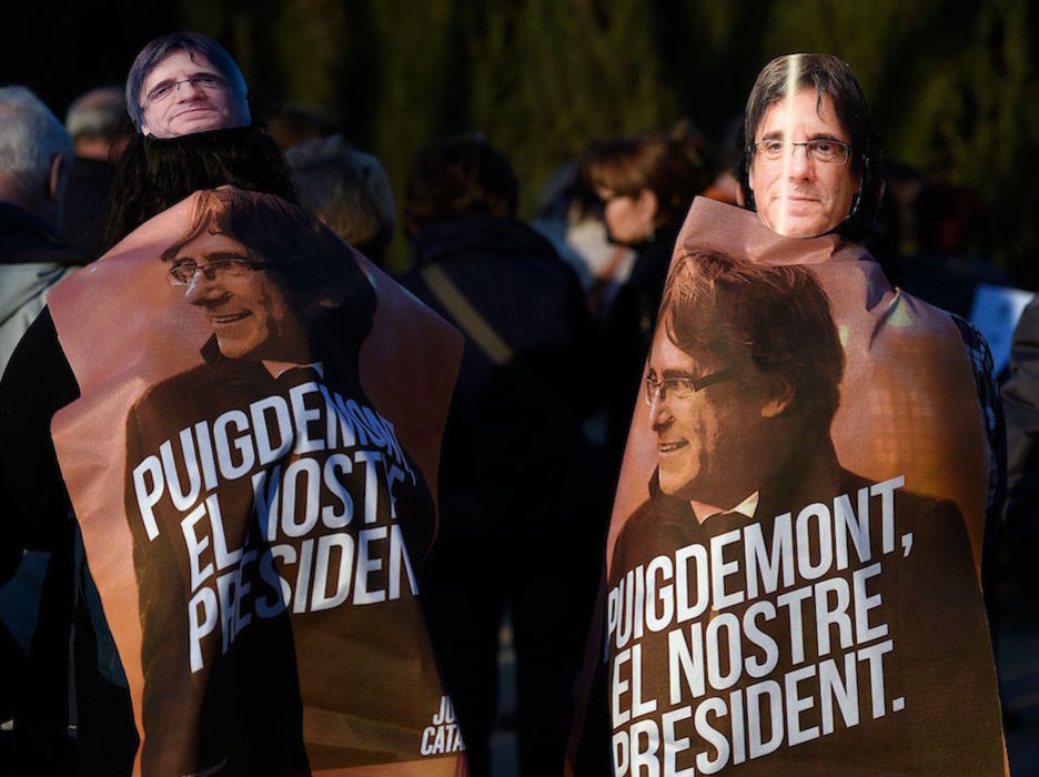 Caretas de Puigdemont y carteles de la campaña electoral. (Lluis GENÉ / AFP)