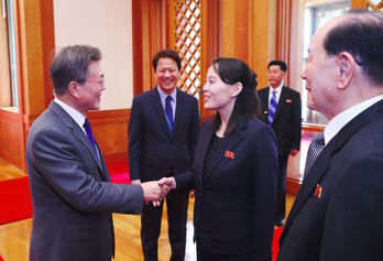 El presidente surcoreano y la hermana del líder norcoreano se saludan. (AFP)