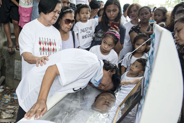 María Lavina llora la muerte de su hijo Rodel en el cementerio de Caloocan Norte. El joven, de 30 años, fue apuñalado por un grupo de hombres enmascarados.  