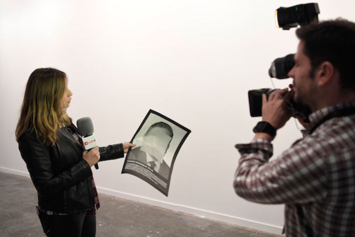 Una periodista de televisión muestra una de las imágenes censuradas. (GABRIEL BOUYS / AFP)