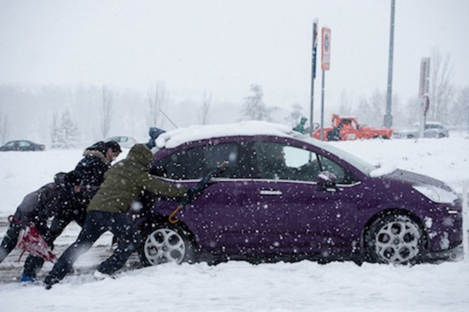 Varias personas empujan un vehículo atrapado en la nieve. (Iñigo URIZ/ARGAZKI PRESS)