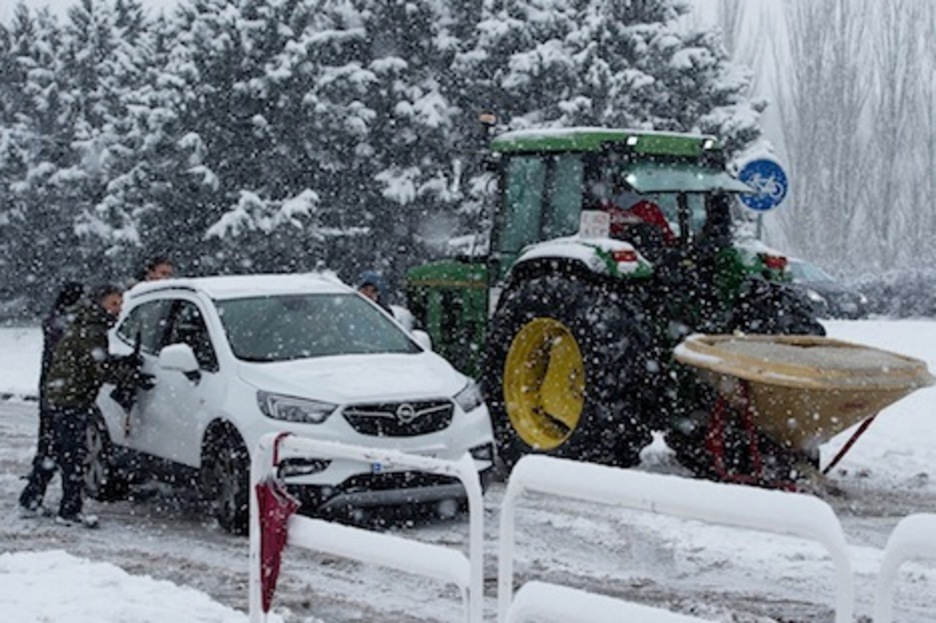 Un tractor que echa sal por la calzada pasa junto a un coche atascado. (Iñigo URIZ/ARGAZKI PRESS) Un tractor que echa sal por la calzada pasa junto a un coche atascado. (Iñigo URIZ/ARGAZKI PRESS)