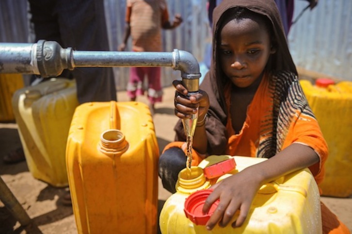 Una niña somalí llena un bidón de agua en un campo para desplazados internos en las afueras de Mogadiscio. (Mohamed ABDIWAHAB/AFP)