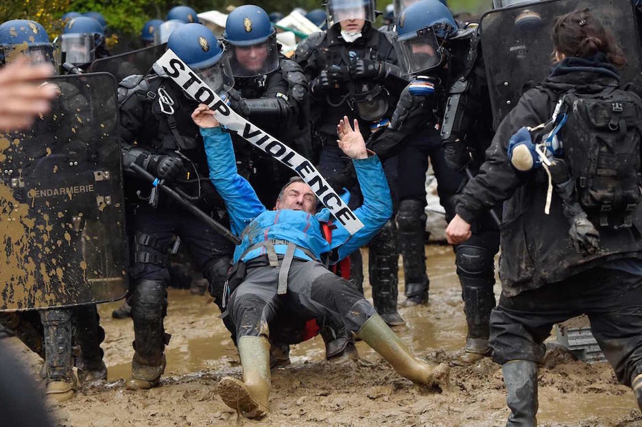 La Policía arrastra a un activista que porta un cartel que dice ‘stop violencia’. (Loic VENANCE / AFP)