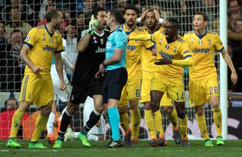Los jugadores de la Juve, con Buffon al frente, protestan al árbitro por el penalti que ha pitado. (CURTO DE LA TORRE  / AFP)