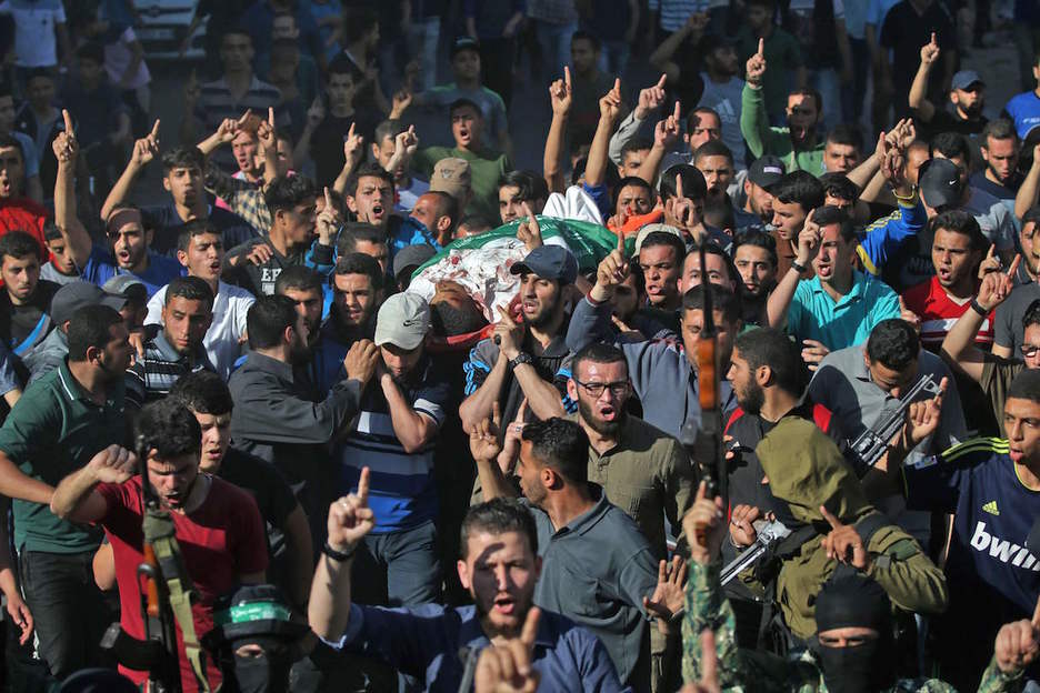 Cientos de personas trasladan a uno de los fallecidos. (Mohammed ABED / AFP)