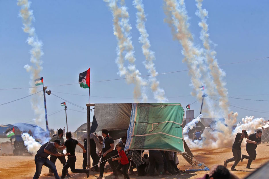 Varios palestinos corren ante los disparos del Ejército de Israel. (Mohammed ABED / AFP)
