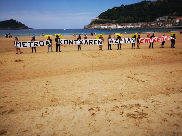 La protesta contra el metro se ha llevado a cabo sobre la arena de La Concha. (@bizitzahandiena)