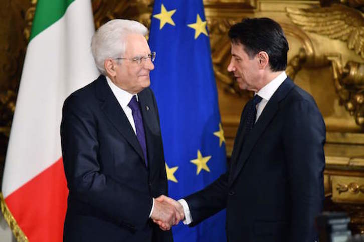 Mattarella estrecha la mano de Conte tras jurar este el cargo de primer ministro. (Alberto PIZZOLI/AFP)