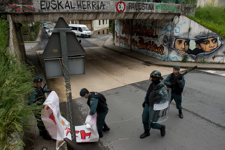 La Guardia Civil retira una pancarta ayer en Altsasu. (Iñigo URIZ / FOKU)
