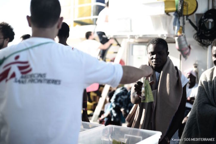 Un miembro de MSF da comida a uno de los migrantes a bordo del ‘Aquarius’. (AFP)
